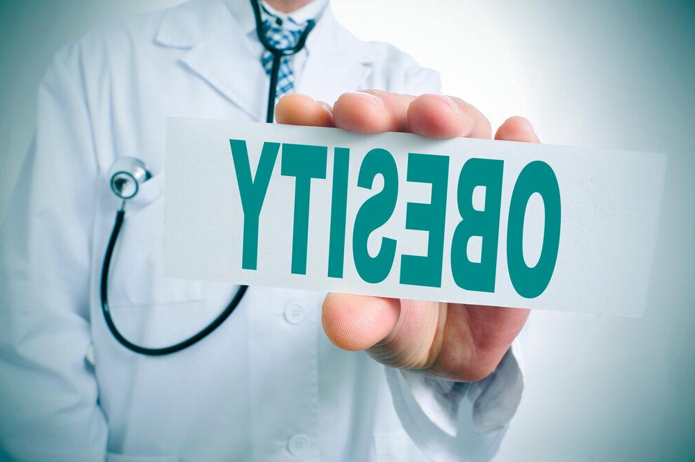 An image of a physician holding a sign that says obesity